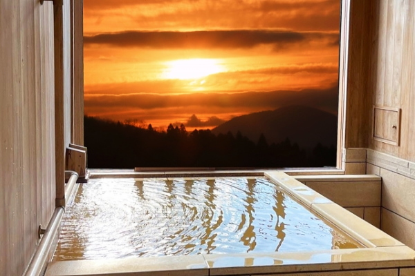 静かな温泉で夕焼けを眺める一人旅のイメージ